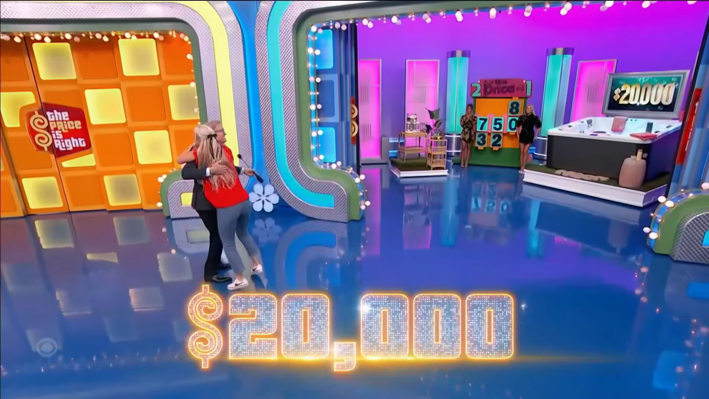 Contestants celebrating on stage with a ,000 prize displayed in sparkling text.